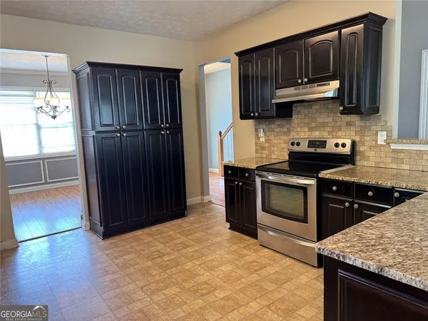a kitchen with stainless steel appliances granite countertop wooden cabinets a stove top oven a sink and dishwasher