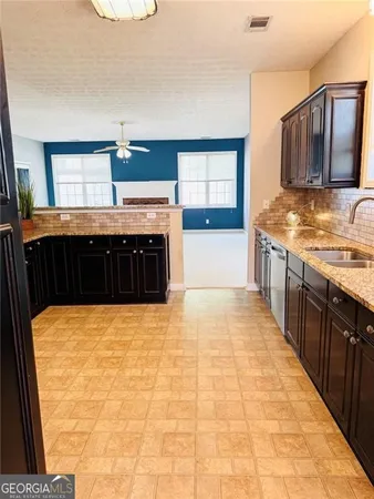 a view of a kitchen with stainless steel appliances granite countertop a stove a sink dishwasher and cabinets