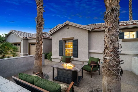 a view of a house with backyard and sitting area