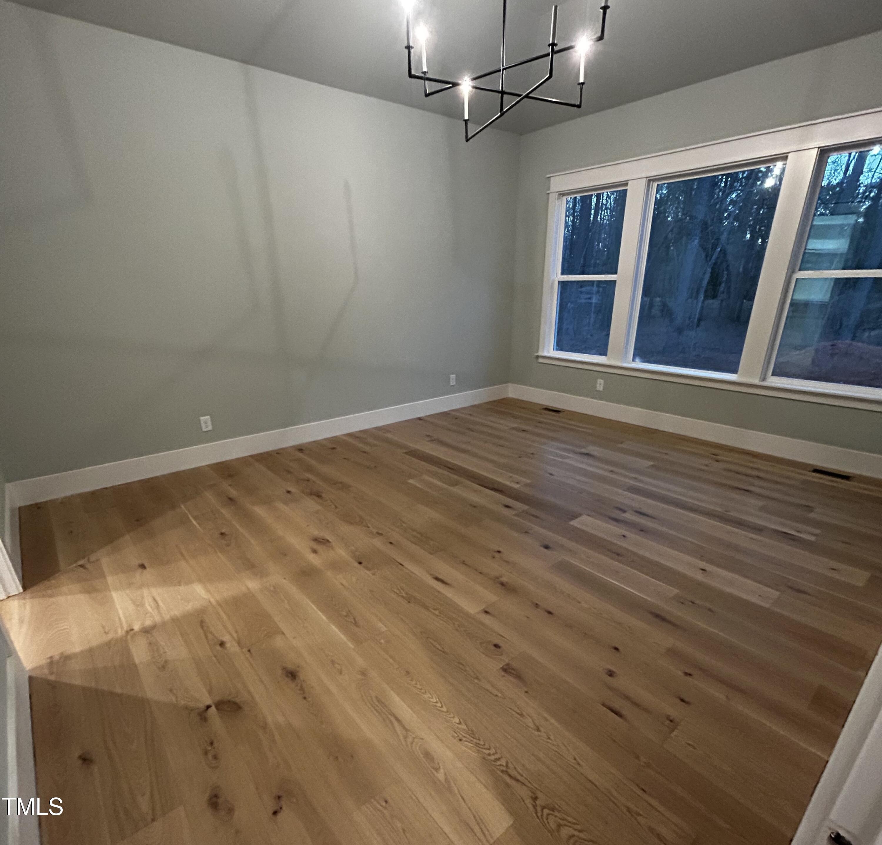 1008 Frank Bailey Road Wake Forest, NC 27587 - Photo 12 of 22 an empty room with wooden floor and windows
