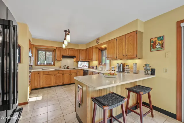 a kitchen with a sink a stove cabinets and a dining table