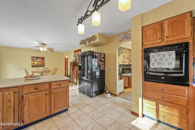 a kitchen with stainless steel appliances kitchen island granite countertop a refrigerator and cabinets