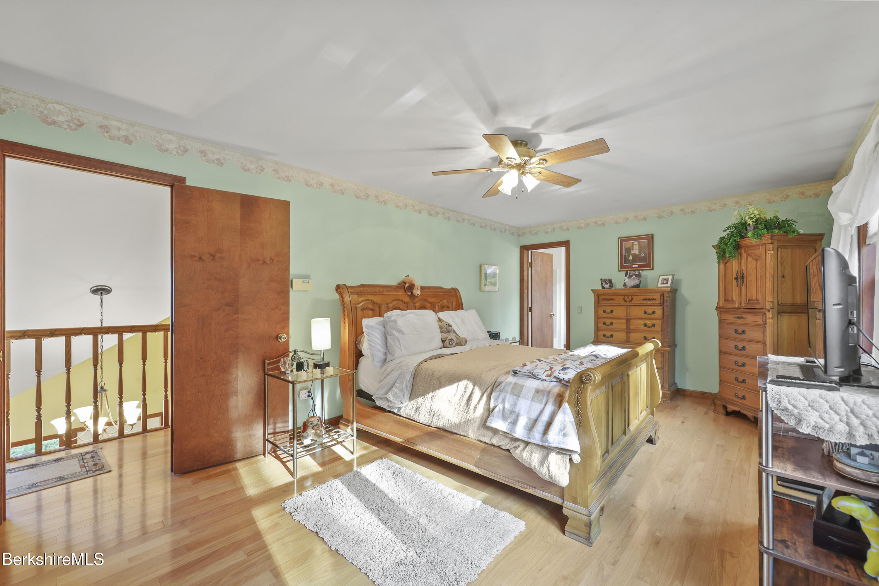 551 Tamarack Road Pittsfield, MA 01201 - Photo 28 of 51 a bedroom with a bed a couch and a chandelier
