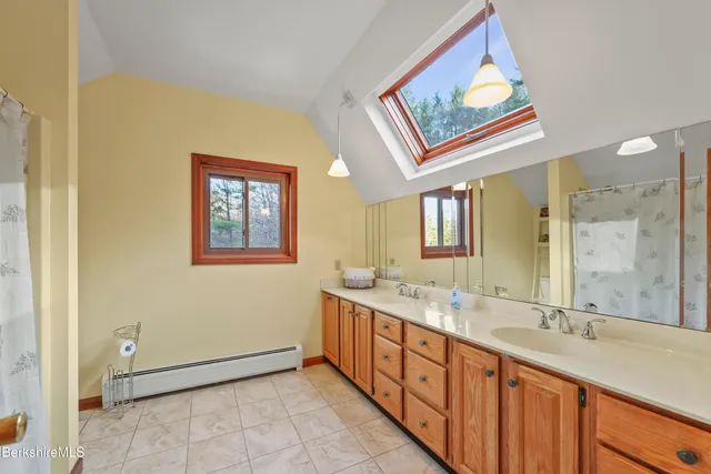 a spacious bathroom with a double vanity sink a mirror and a bathtub