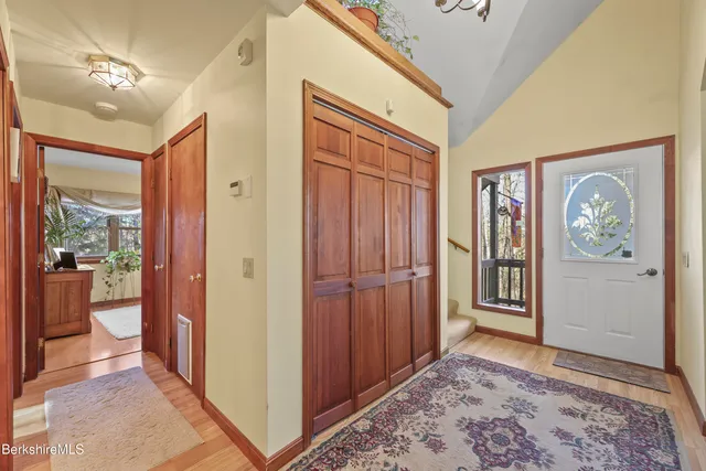 a view of a hallway with wooden floor and windows