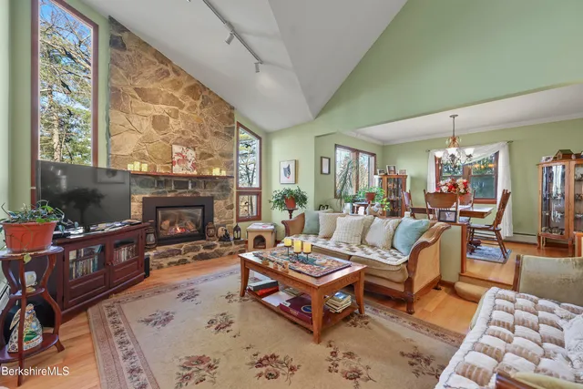 a living room with furniture a fireplace and a large window