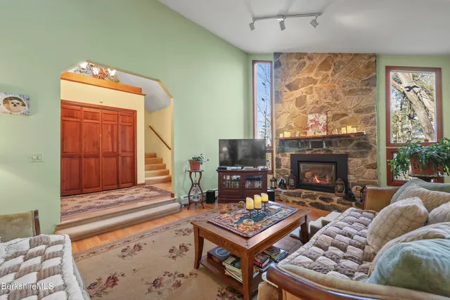 a living room with furniture a flat screen tv and a fireplace