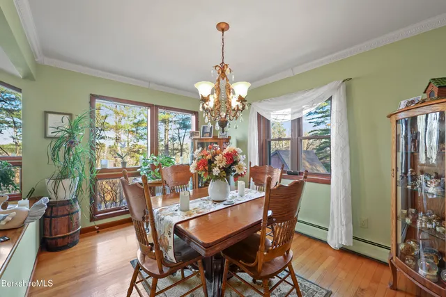 a dining room with furniture a chandelier and wooden floor