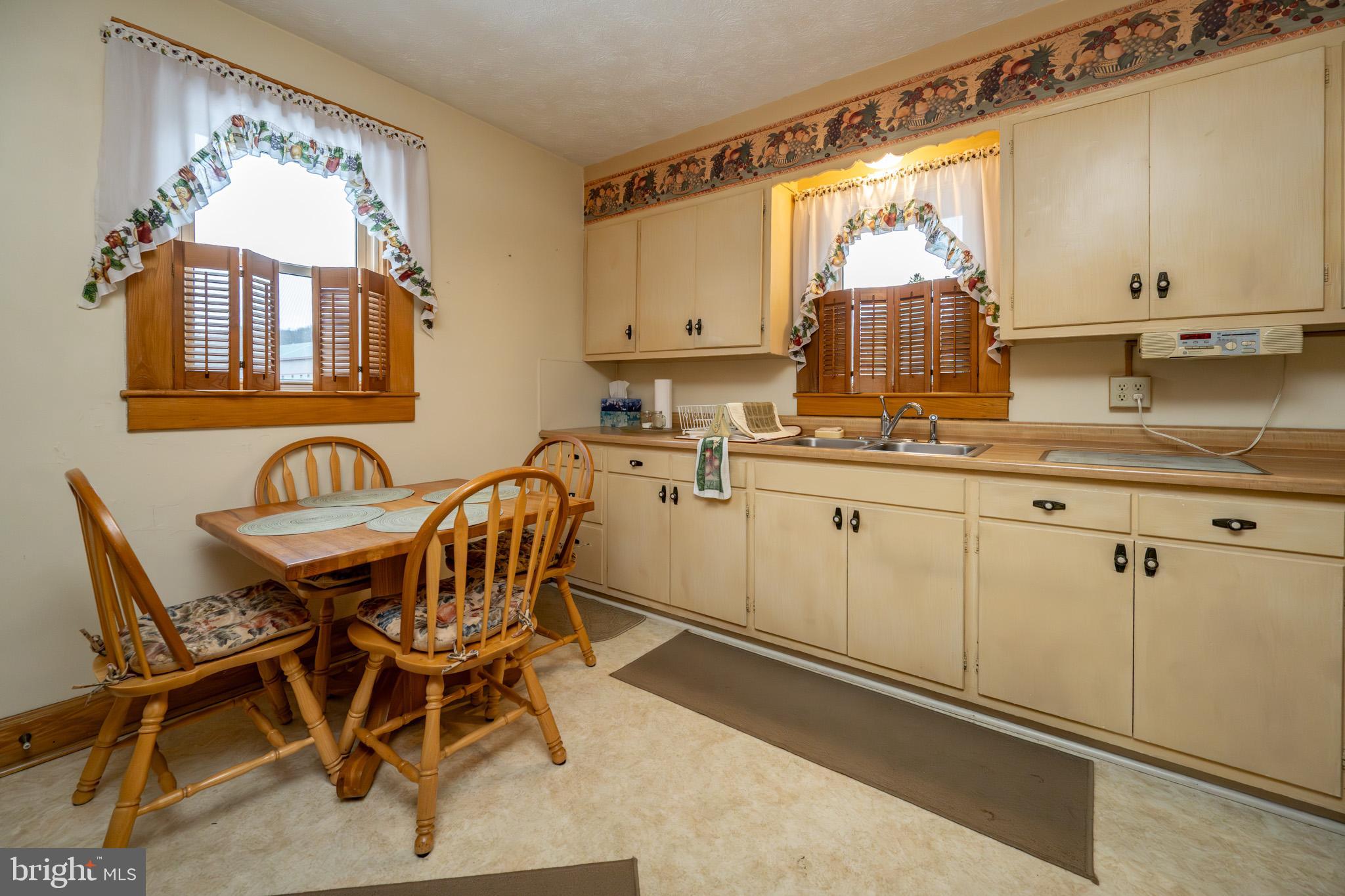 313 West Liberty Street Oakland, MD 21550 - Photo 11 of 59 a kitchen with a table chairs sink and cabinets