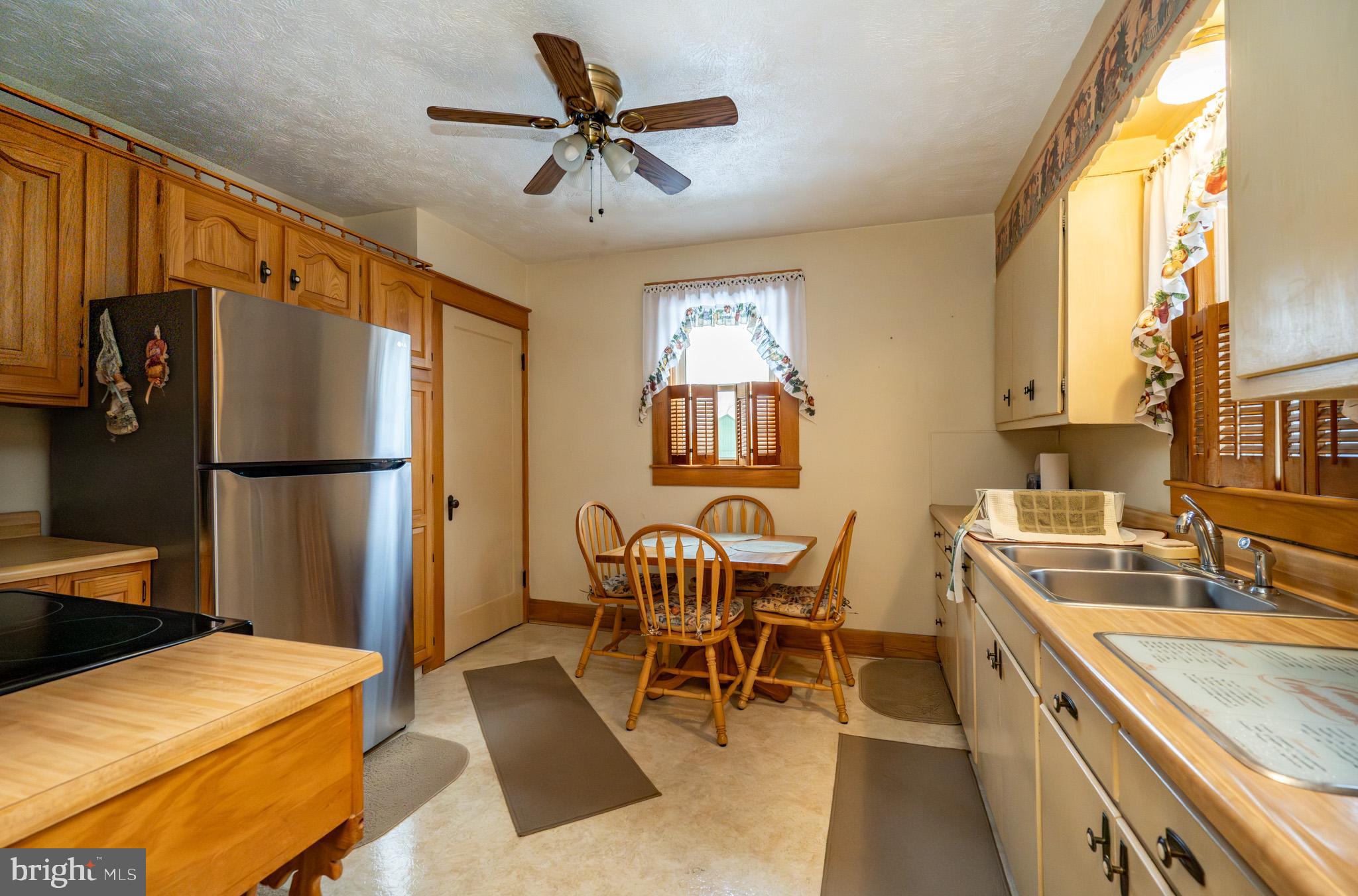 313 West Liberty Street Oakland, MD 21550 - Photo 12 of 59 a kitchen with a table chairs refrigerator and cabinets