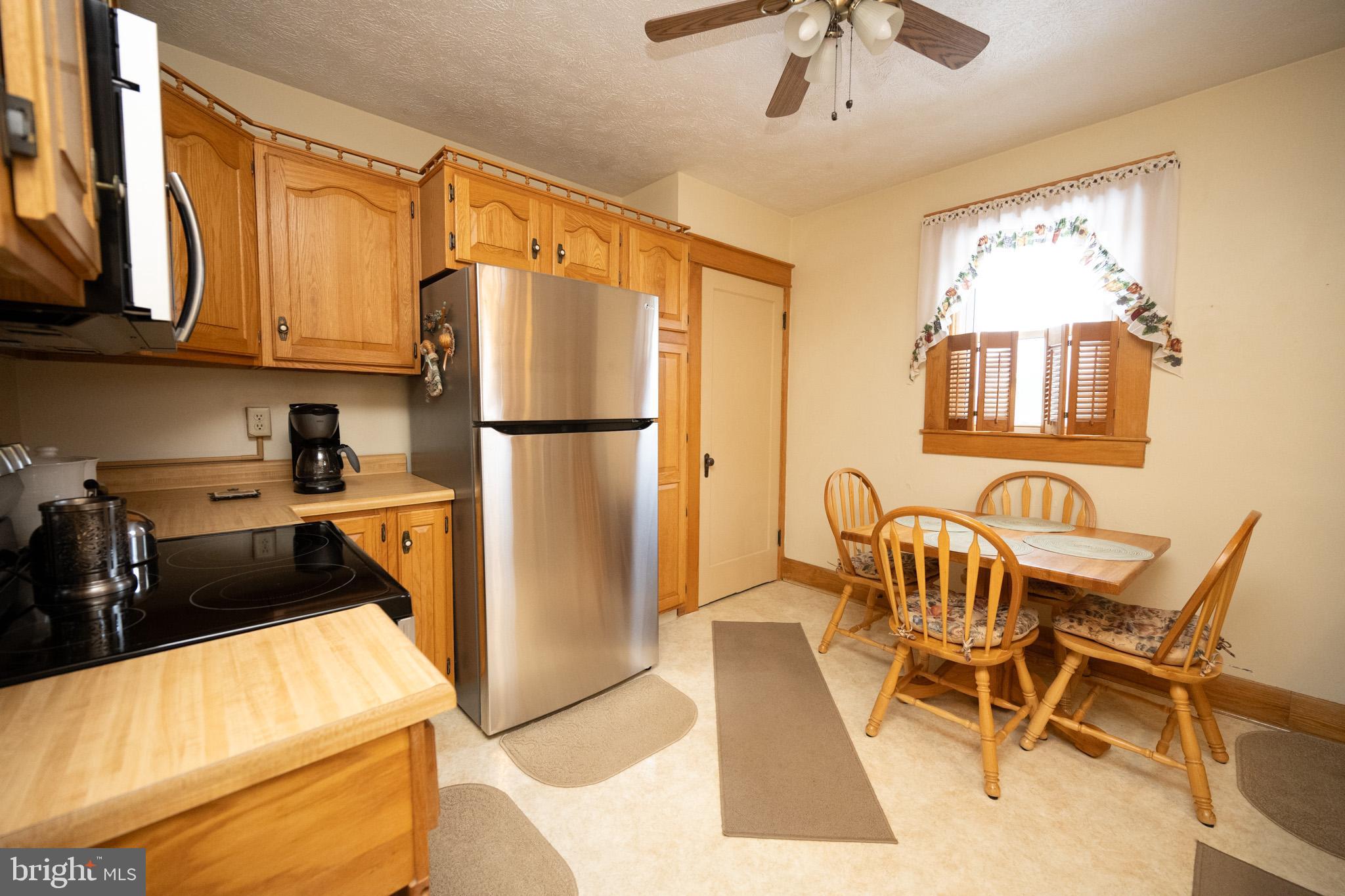 313 West Liberty Street Oakland, MD 21550 - Photo 13 of 59 a kitchen with stainless steel appliances granite countertop a refrigerator a sink a stove and white cabinets