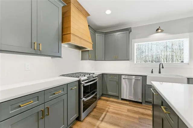a kitchen with stainless steel appliances granite countertop a sink a stove and a refrigerator