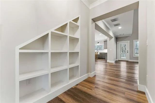 a view of a hallway with wooden floor and staircase