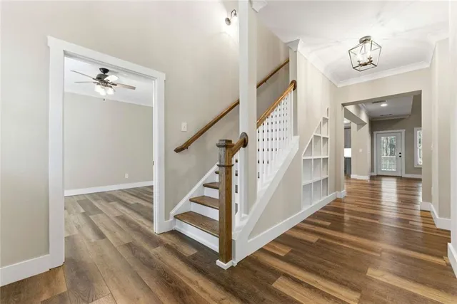 a view of a hallway with wooden floor and staircase