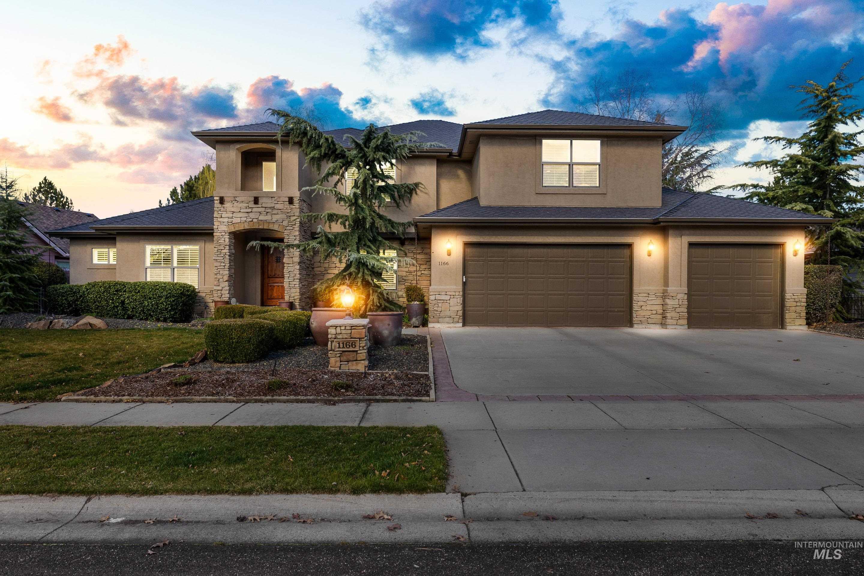 1166 East Rivers End Drive Eagle, ID 83616 - Photo 2 of 50 View of front facade featuring stone siding, driveway, stucco siding, and a garage