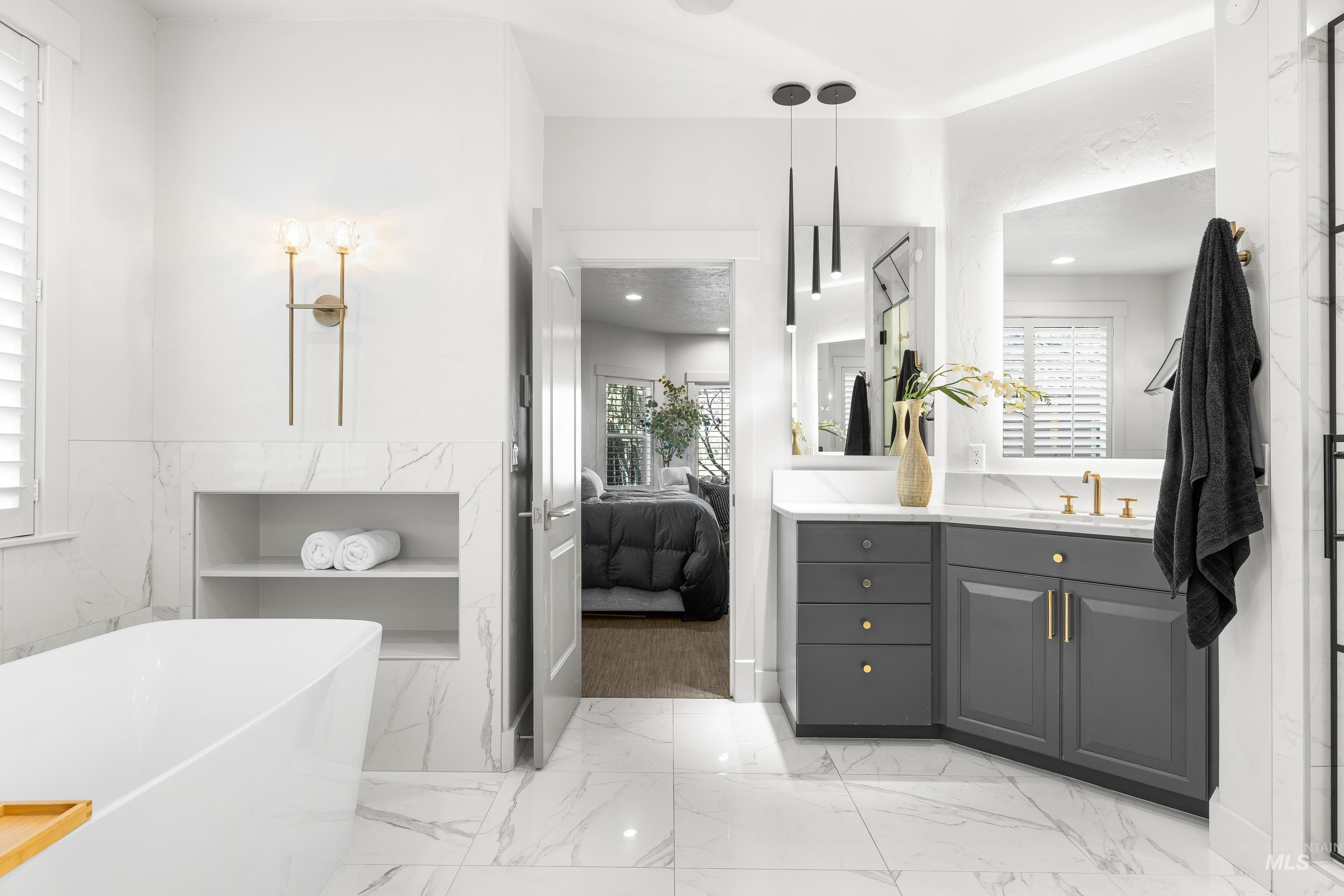 1166 East Rivers End Drive Eagle, ID 83616 - Photo 26 of 50 Ensuite bathroom featuring vanity, plenty of natural light, light marble finish flooring, and a freestanding bath