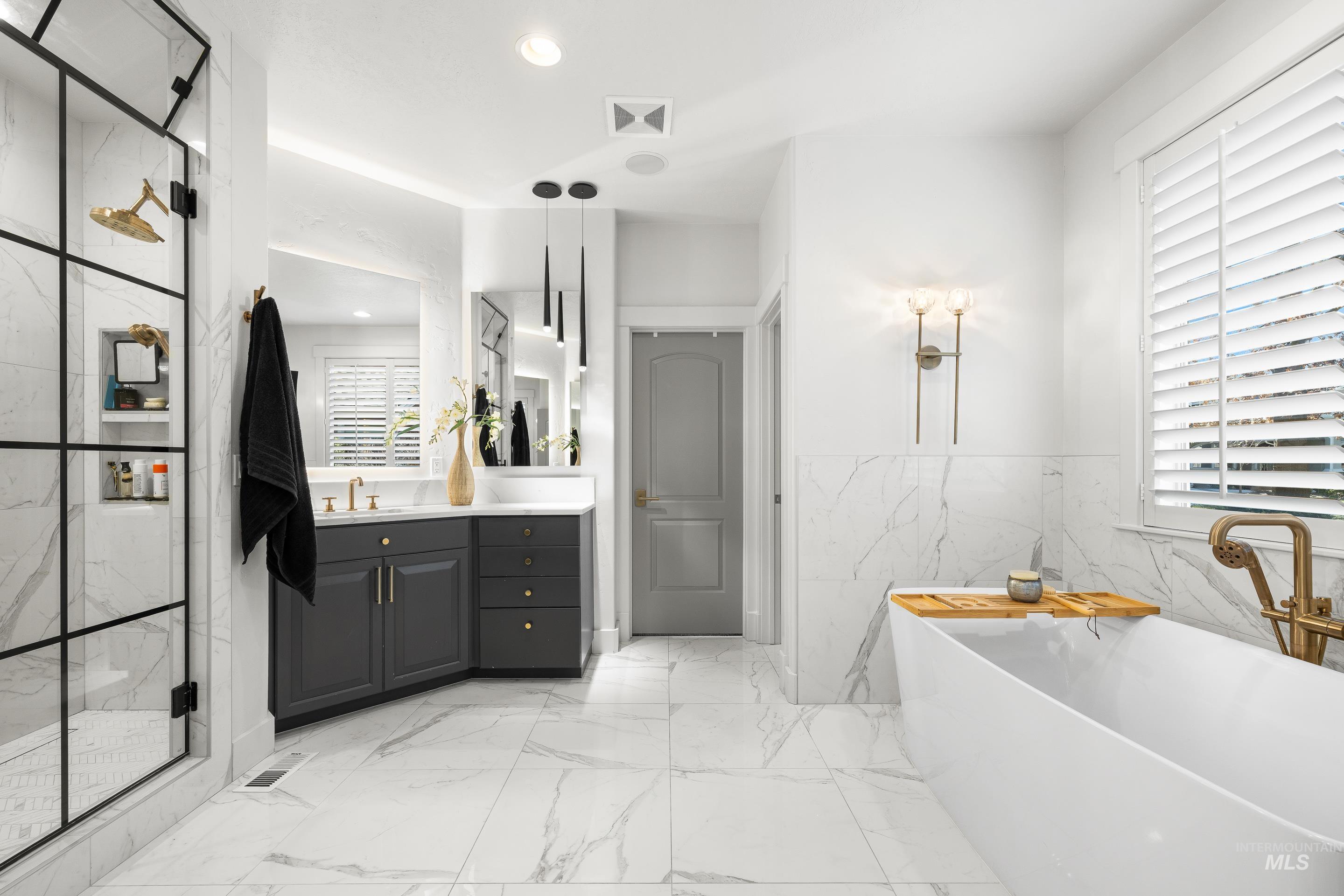 1166 East Rivers End Drive Eagle, ID 83616 - Photo 29 of 50 Bathroom with vanity, a soaking tub, a marble finish shower, recessed lighting, and tile walls