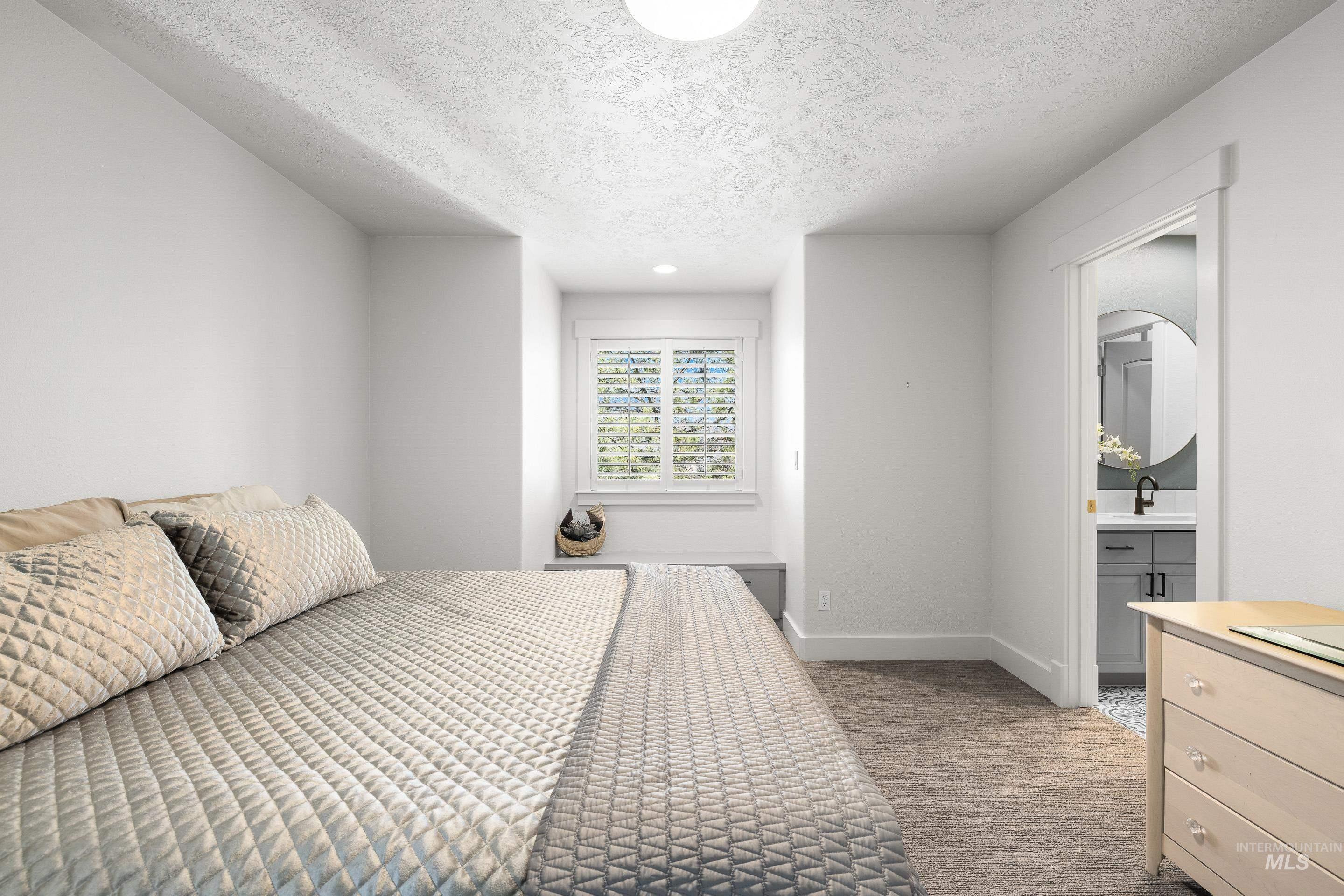 1166 East Rivers End Drive Eagle, ID 83616 - Photo 32 of 50 Bedroom with light carpet, a textured ceiling, connected bathroom, and recessed lighting