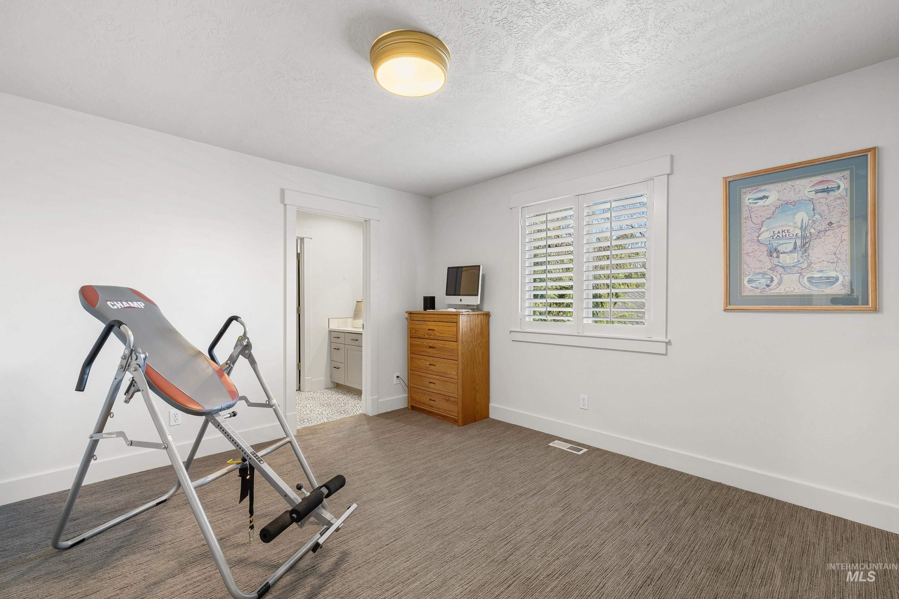 1166 East Rivers End Drive Eagle, ID 83616 - Photo 34 of 50 Exercise area featuring a textured ceiling and dark colored carpet
