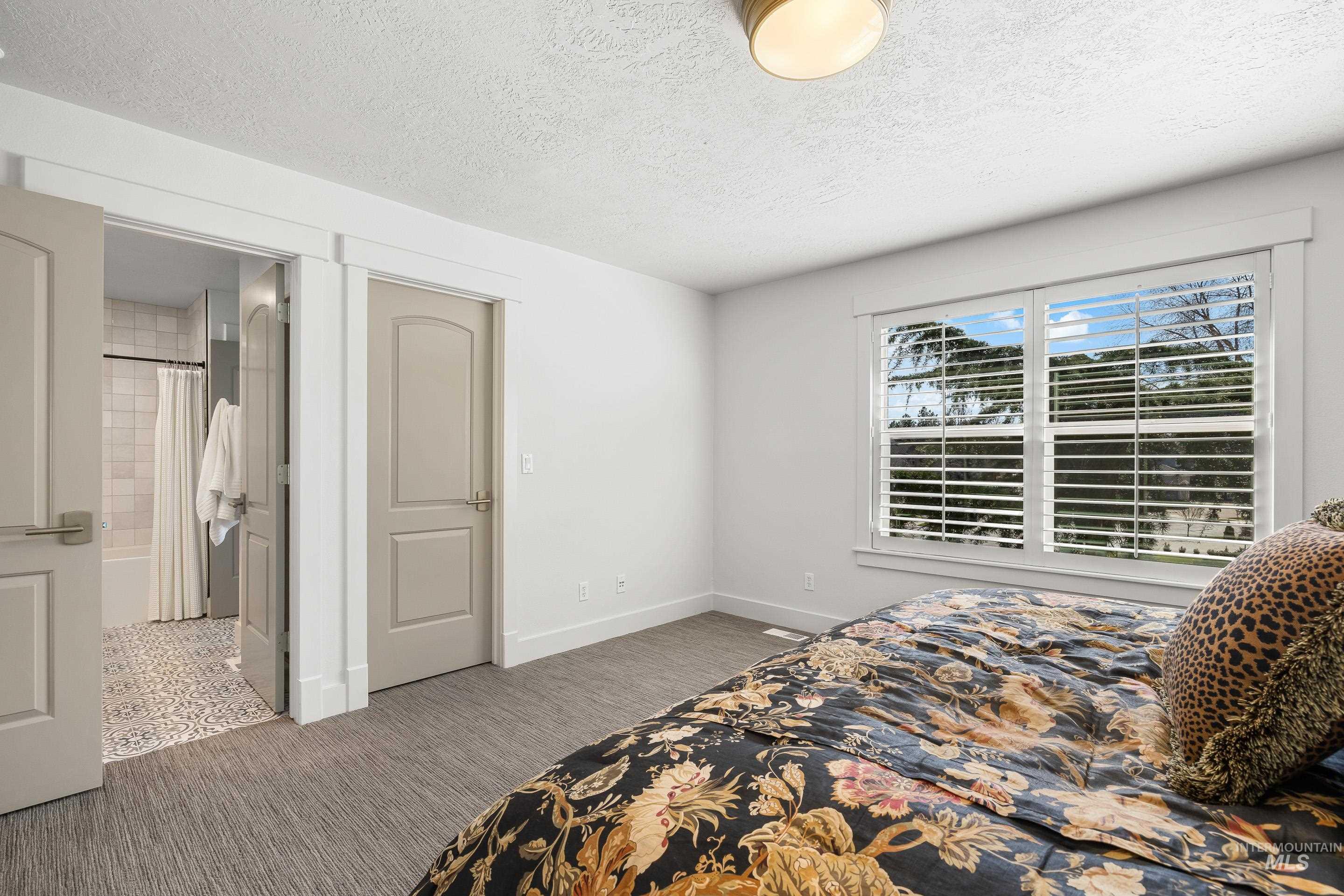 1166 East Rivers End Drive Eagle, ID 83616 - Photo 40 of 50 Bedroom with a textured ceiling, light carpet, and connected bathroom