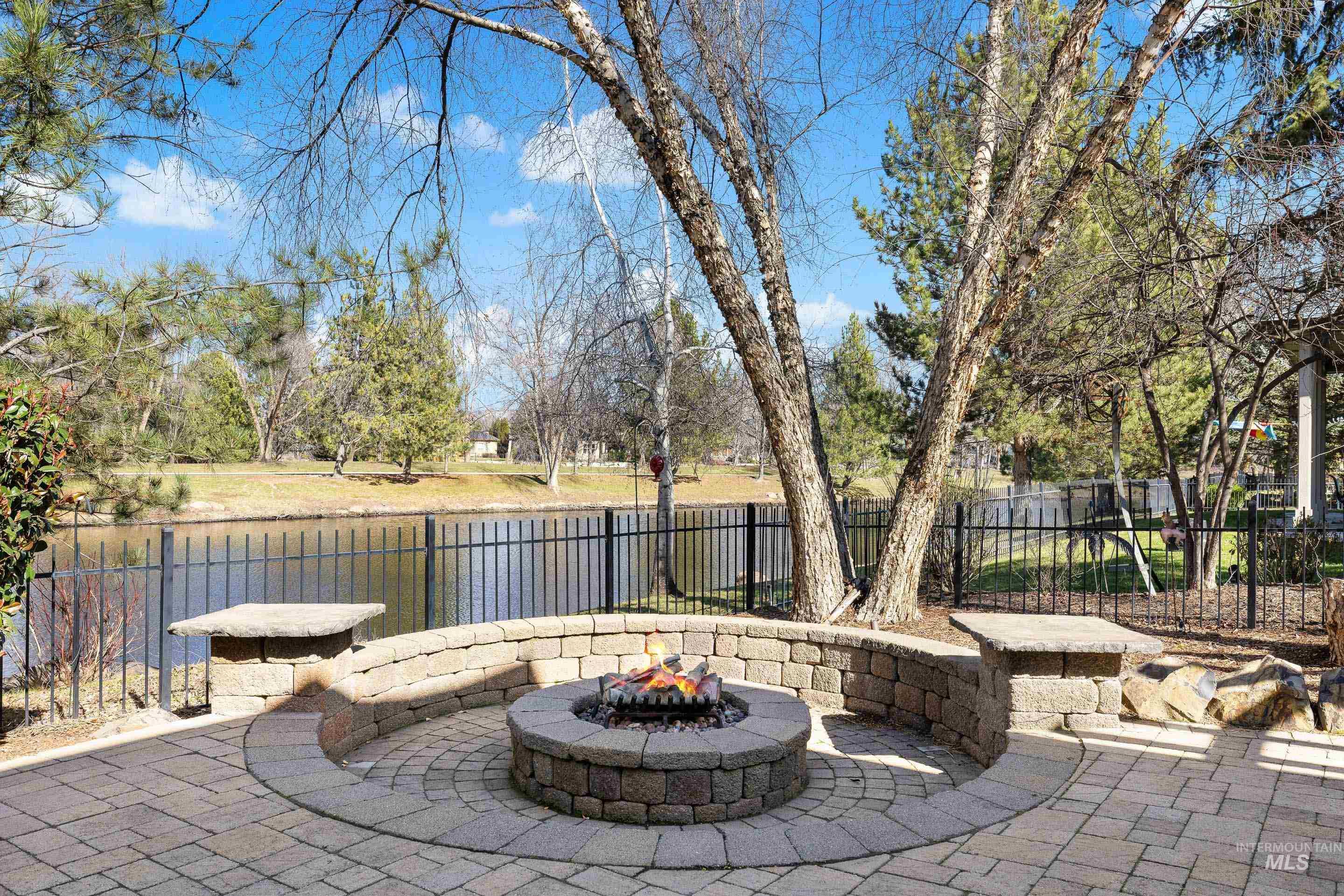 1166 East Rivers End Drive Eagle, ID 83616 - Photo 46 of 50 Fenced backyard with a fire pit, a patio area, and a water view