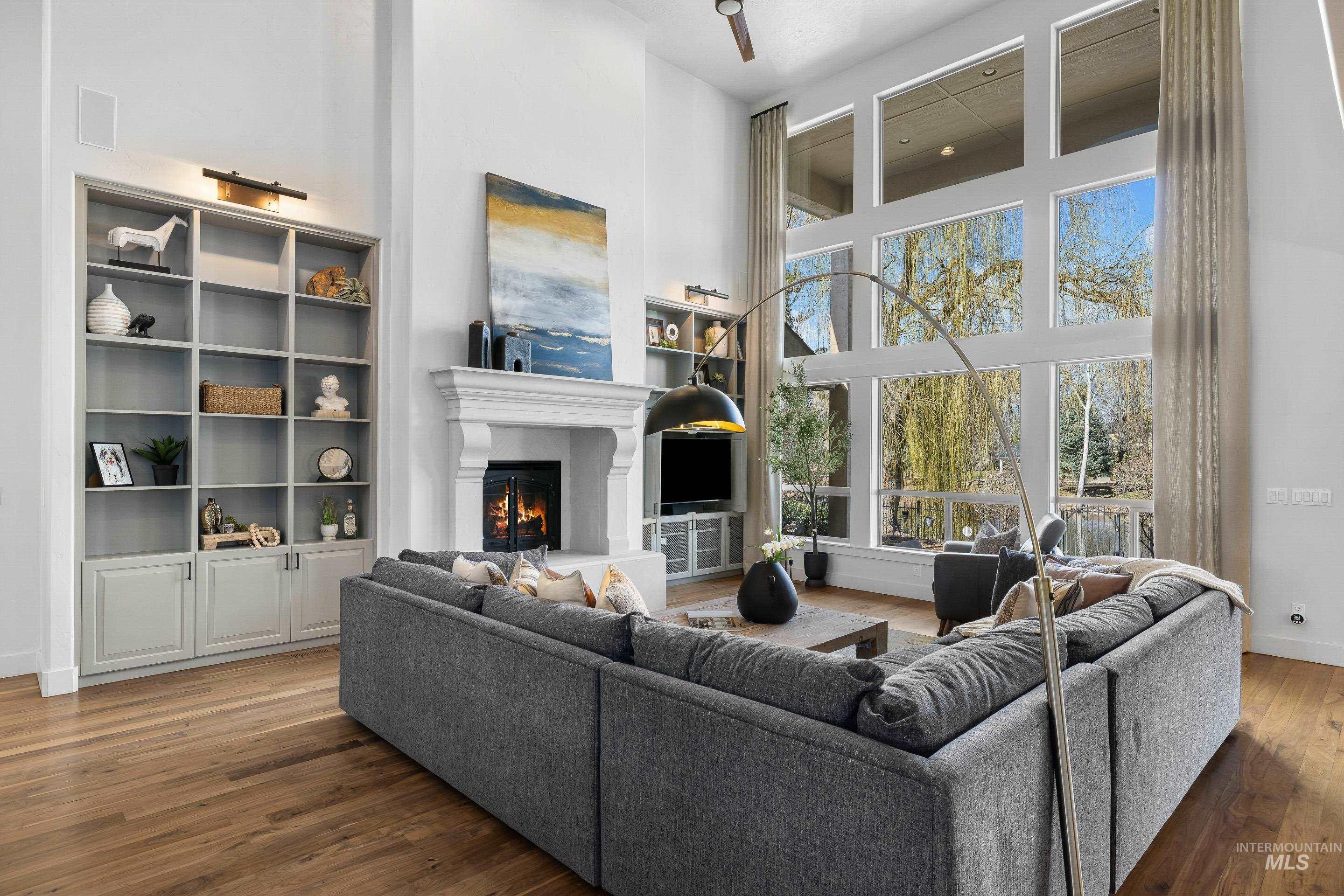 1166 East Rivers End Drive Eagle, ID 83616 - Photo 7 of 50 Living room featuring a high ceiling, wood finished floors, and a lit fireplace