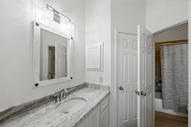 a bathroom with a granite countertop sink vanity and mirror
