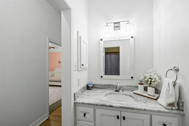 a bathroom with a granite countertop sink and a mirror