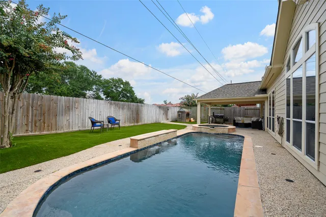 a swimming pool with outdoor seating and yard