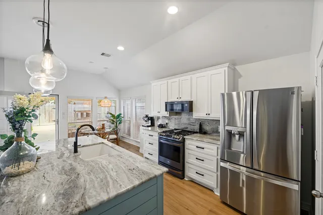 a kitchen with refrigerator a sink and cabinets
