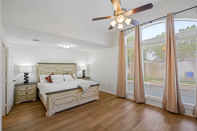 a bedroom with a large bed chandelier and a window