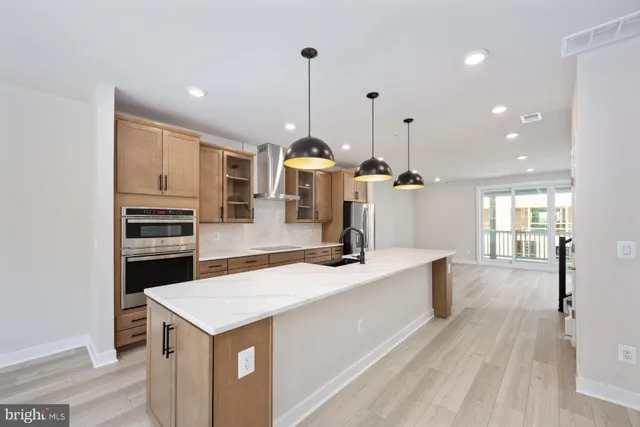 a kitchen with stainless steel appliances granite countertop a sink a stove and a wooden floors