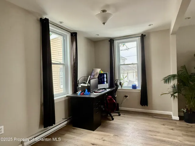 a view of a workspace with furniture and a window