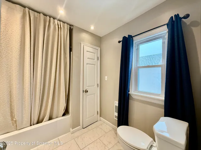 a bathroom with a toilet a sink and shower