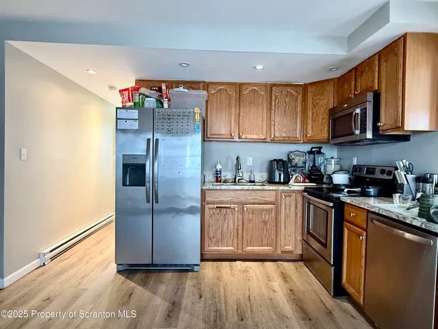 a kitchen with stainless steel appliances granite countertop a refrigerator sink and cabinets