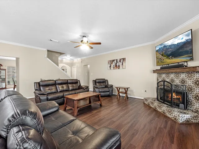 a living room with furniture a flat screen tv and a fireplace