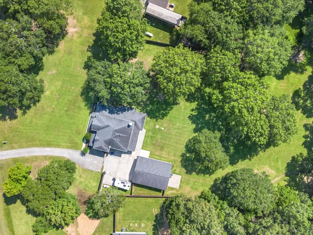 an aerial view of a house with a yard and lake view