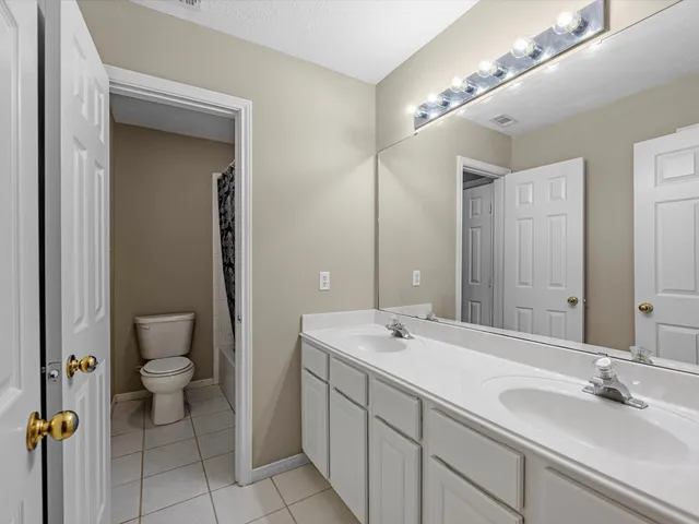 a bathroom with a sink and mirror with toilet