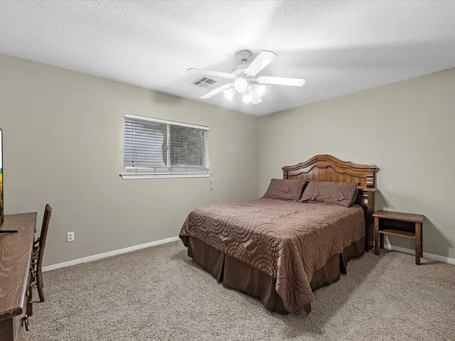 a spacious bedroom with a bed and a chandelier