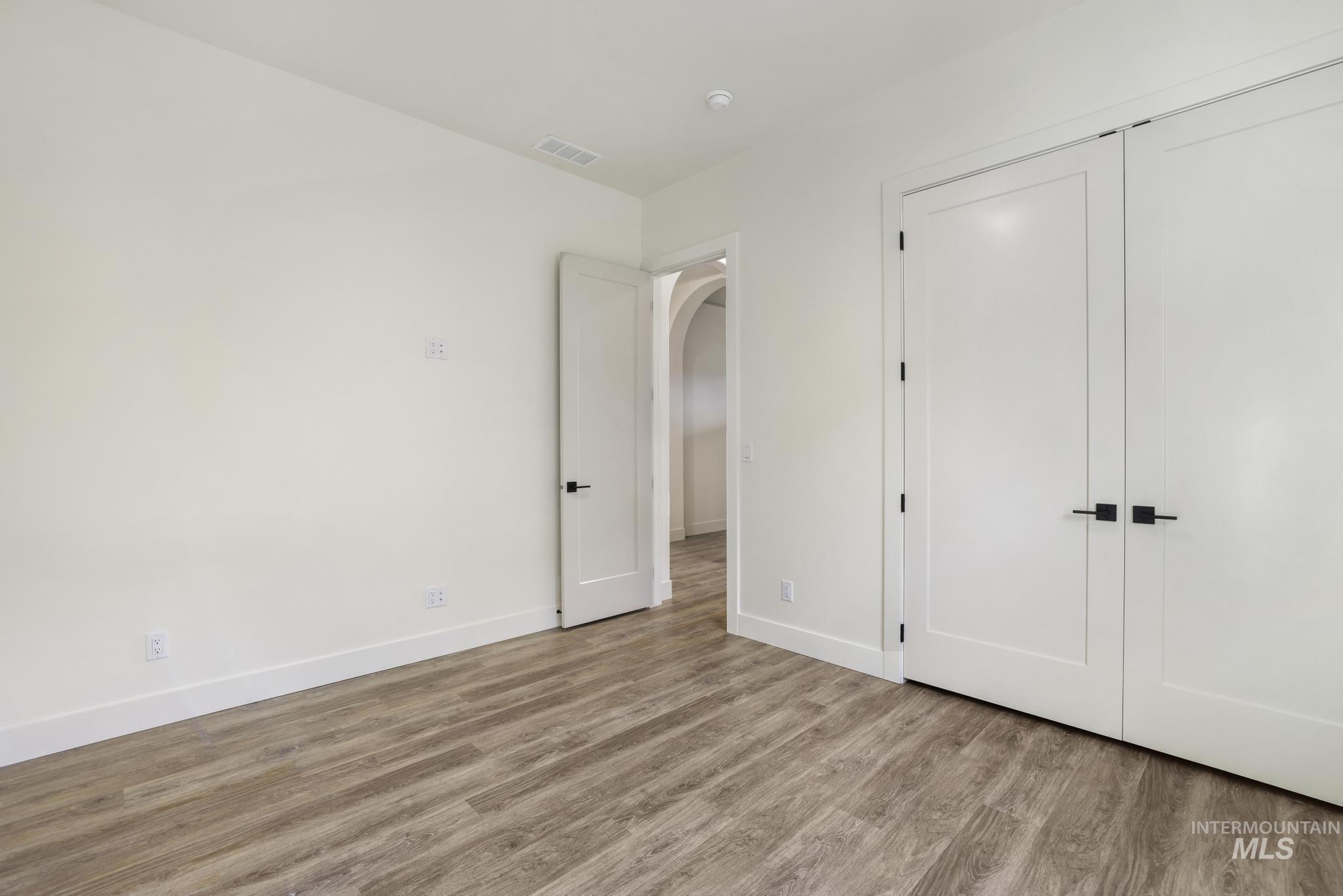 542 Falling Leaf Lane Twin Falls, ID 83301 - Photo 28 of 38 Unfurnished bedroom featuring wood finished floors, arched walkways, and a closet