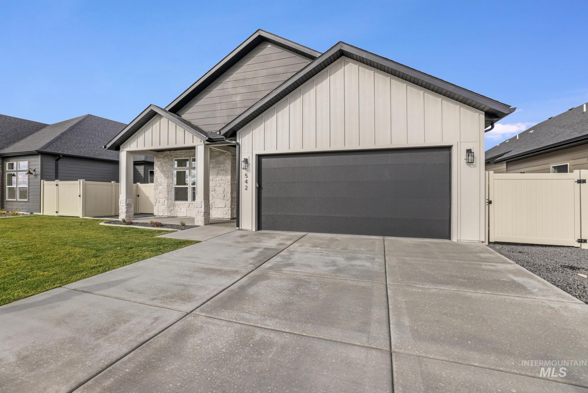 542 Falling Leaf Lane Twin Falls, ID 83301 - Photo 8 of 38 View of front of house with board and batten siding, a gate, a garage, and concrete driveway