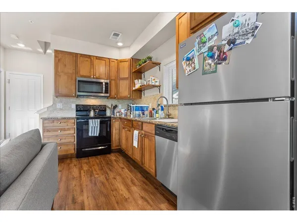 a kitchen with stainless steel appliances granite countertop a refrigerator sink and microwave