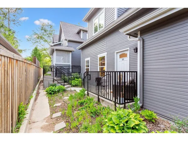 a view of a house with a small yard and wooden floor and fence