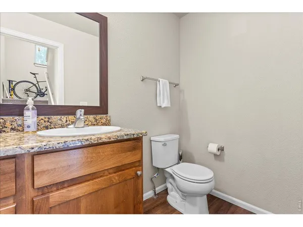 a bathroom with a granite countertop toilet a sink and a mirror