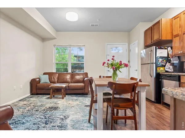 a living room with furniture a dining table and a bookshelf