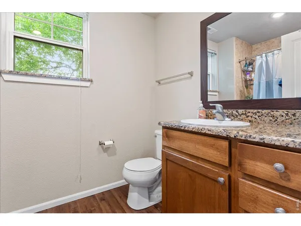 a bathroom with a granite countertop sink toilet and mirror