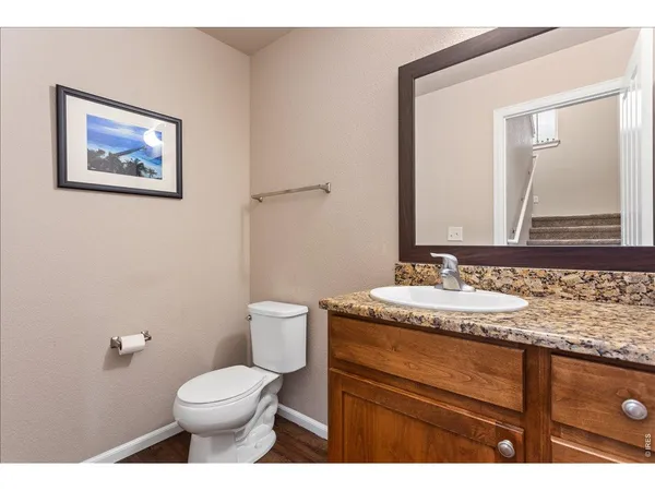a bathroom with a granite countertop toilet sink and mirror