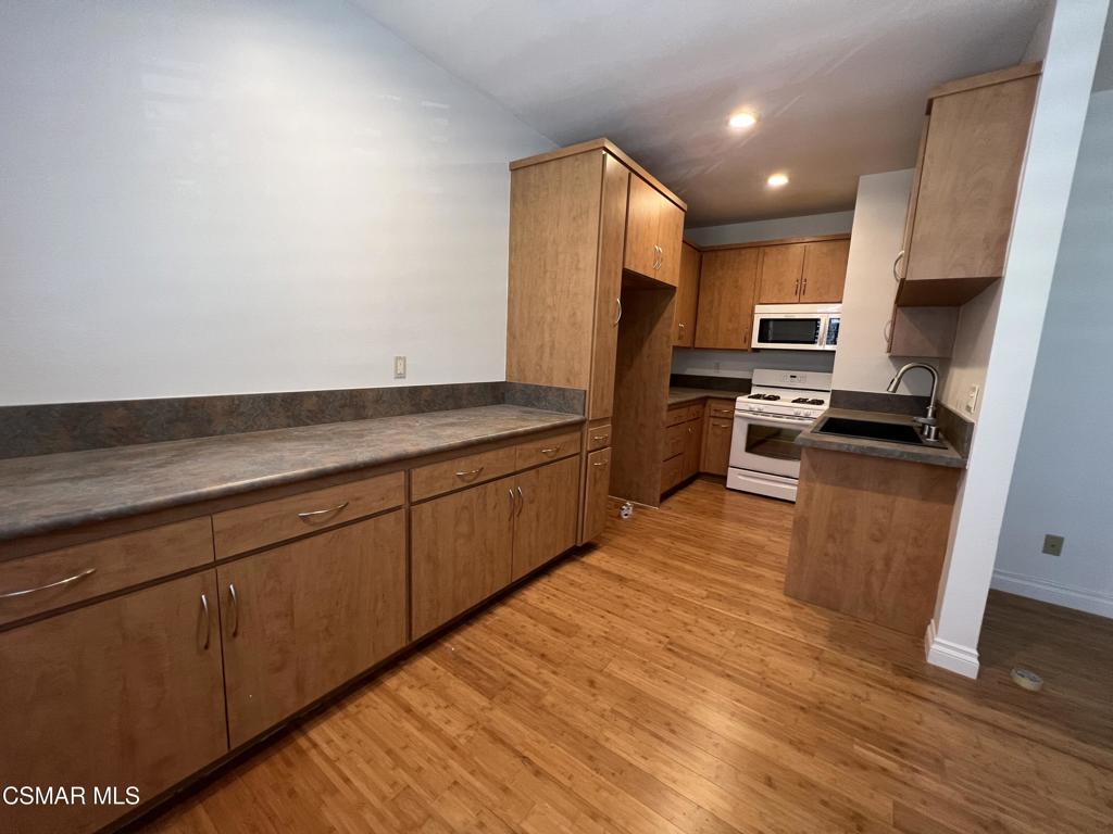 86 Maegan Place, Unit 10 Thousand Oaks, CA 91362 - Photo 3 of 15 a kitchen with stainless steel appliances granite countertop a refrigerator sink and microwave