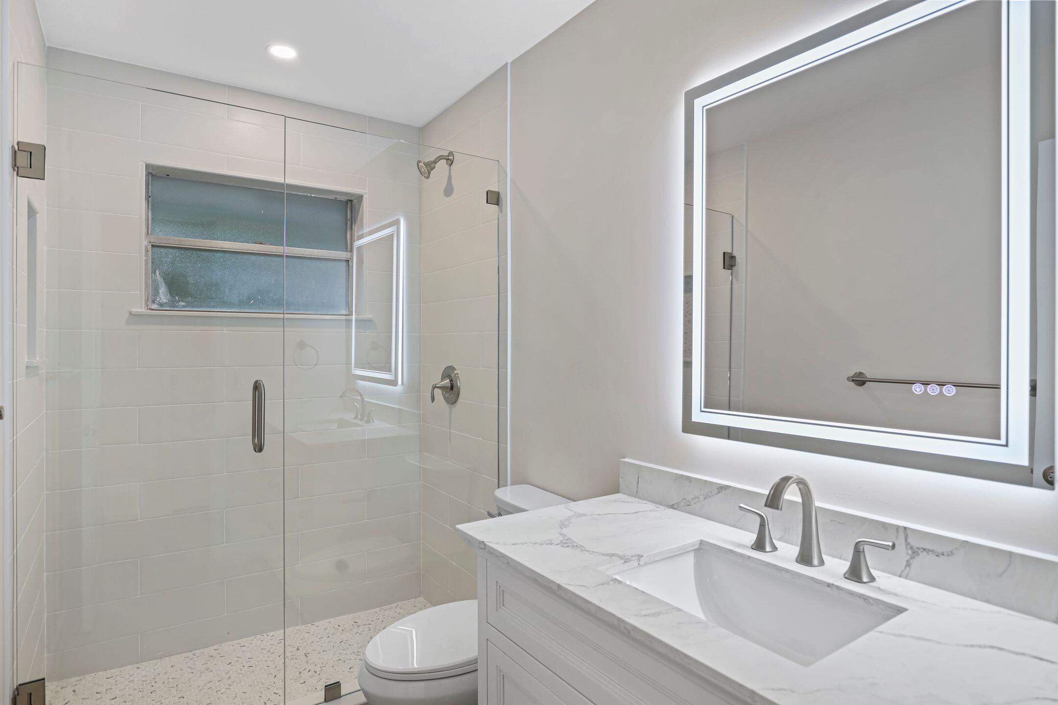 2929 Southeast Ocean Boulevard, Unit 1406 Stuart, FL 34996 - Photo 15 of 27 a bathroom with a sink a toilet and shower