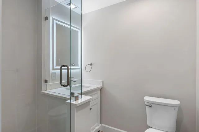 a bathroom with a sink a toilet and mirror